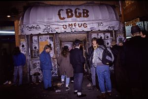 People stand on sidewalk outside of CBCB nightclub.